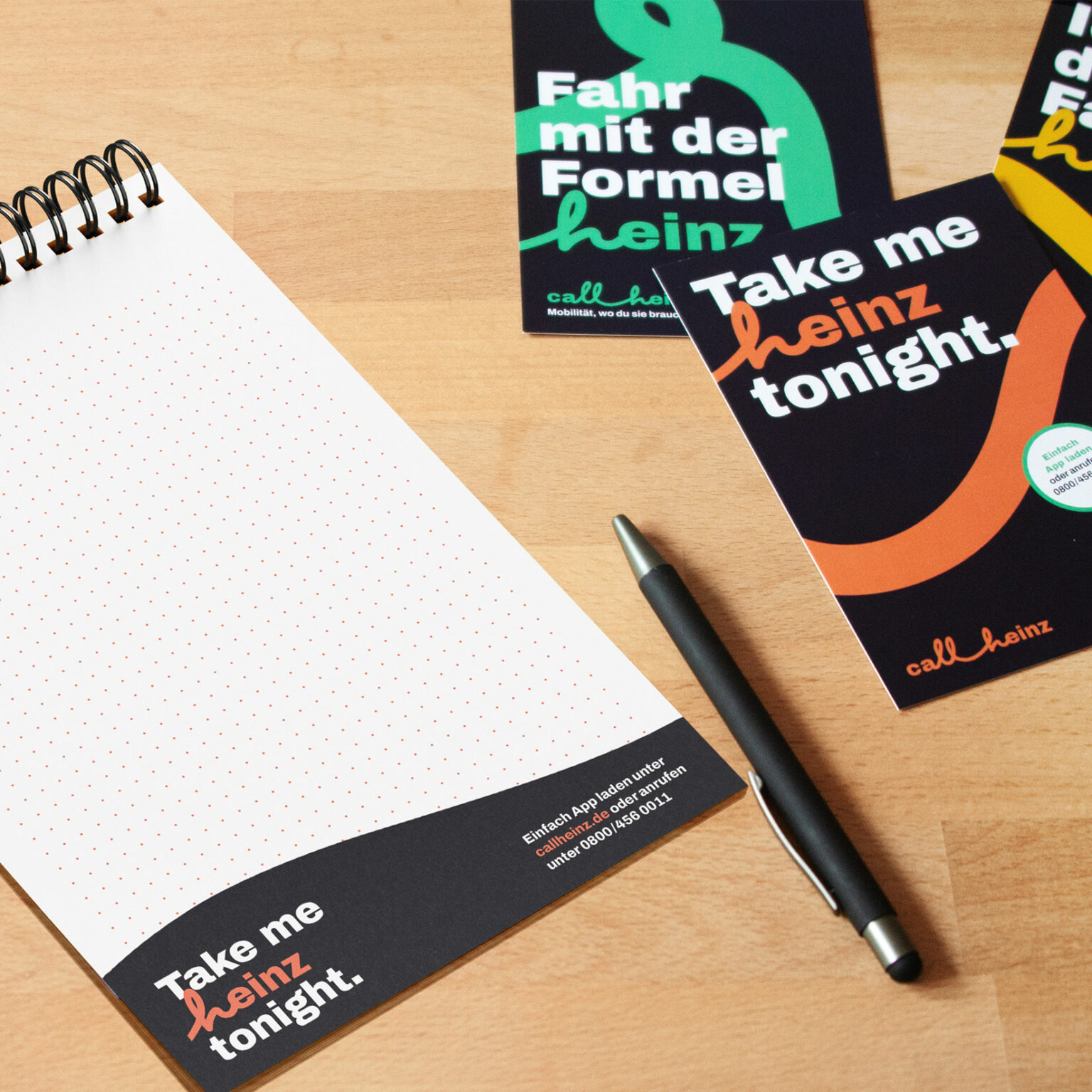 Flyer und Notizblöcke, die beim Gestalten des Corporate Design für callheinz entstanden sind