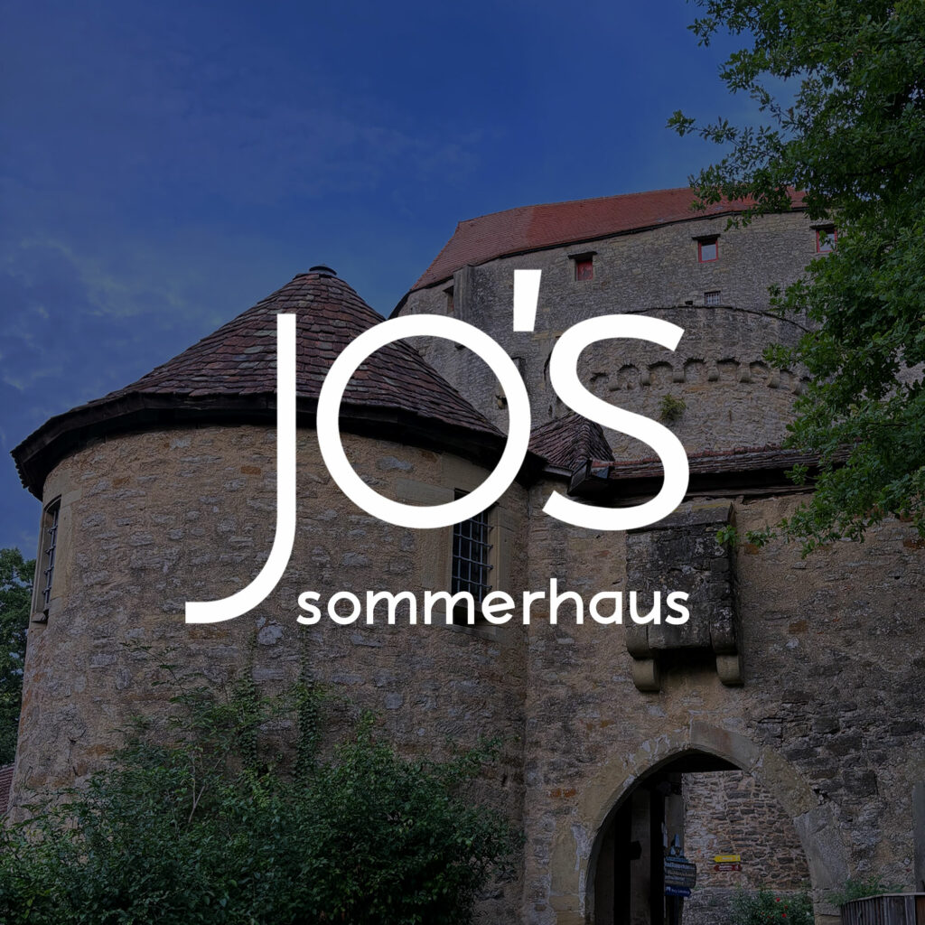 Dach der Burg Guttenberg mit jo's Sommerhaus Logo darüber.
