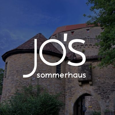 Dach der Burg Guttenberg mit jo's Sommerhaus Logo darüber.